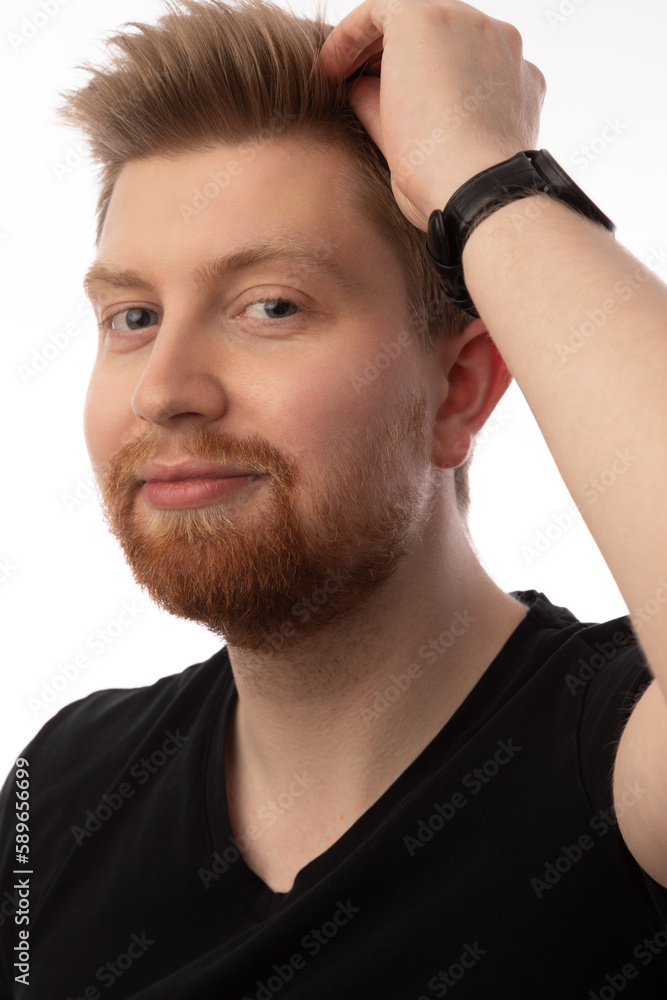 Studio head shot portrait of a handsome caucasian man in his 20s. He is wearing a black shirt and has strawberry blonde hair and a beard. He has blue eyes. Studio head shot portrait of a handsome caucasian man in his 20s. He is wearing a black shirt and has strawberry blonde hair and a beard. He has blue eyes.