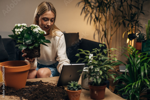 A young business woman takes orders while potting a plant