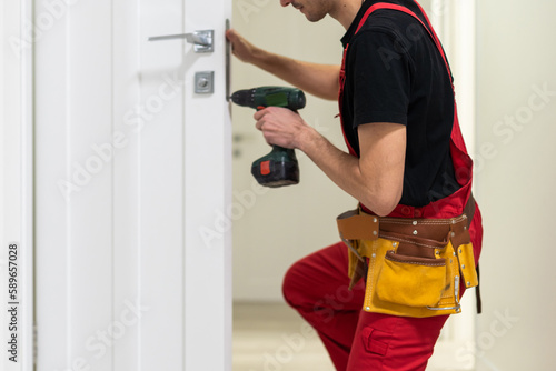 Fotografia The master adjusts the fittings in the doors