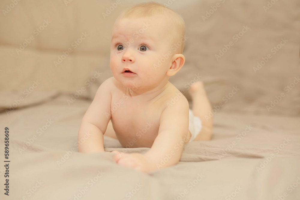 a baby with gray eyes in a diaper is lying in a crib looking away. High quality photo