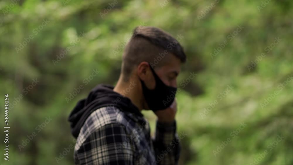 Caucasian man wearing face mask talking on the mobile phone on outdoor background Caucasian man wearing face mask talking on the mobile phone on outdoor background