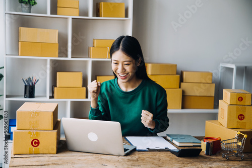 SME entrepreneur Small business entrepreneurs Online selling ideas,Happy Young Asian business owner work on computer and a boxs at home,delivery SME procurement package box deliver to customers,