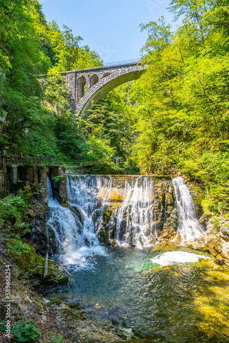 Fototapeta Naklejka Na Ścianę i Meble -  Stone railway viaduct over the Radovna river waterfall in the Vintgar Gorge. Triglav National Park, Slovenia.