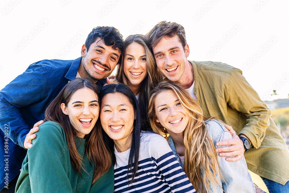 Happy group of young friends smiling at camera outdoors. Multiracial people having fun together. Happy group of young friends smiling at camera outdoors. Multiracial people having fun together.