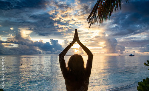 woman doing yoga on exotic beach