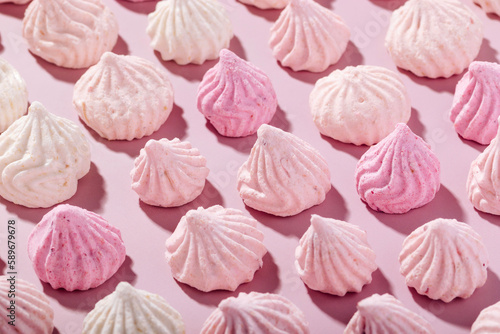 Photography Pink meringue cookies with berry flavor on a pink background