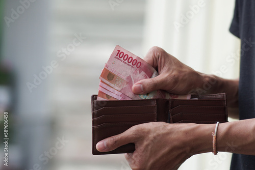 Hands taking out money from wallet Concept of savings, salary, payment and funds