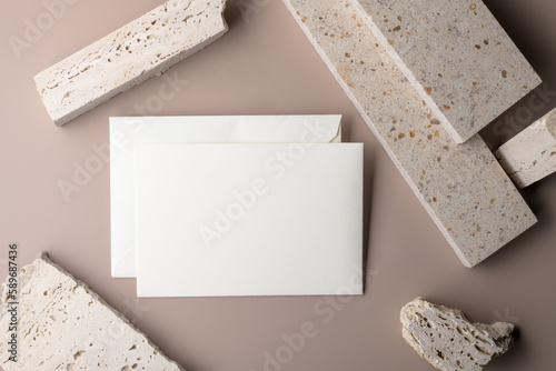 Wedding stationery invitation card mockup 7x5 on beige background with envelop and pieces of travertne marble stone. Minimal bohemian style blank mockup, thank you card, greeting card photo