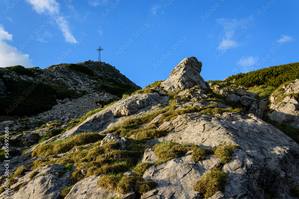 The Cross on top of the mountain against the blue sky.