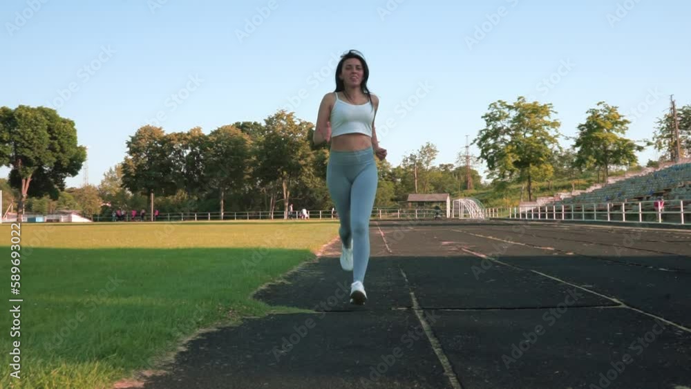 Sportive girl at stadium. Fit woman relaxing at football field. Shape beautiful girl Sportive girl at stadium. Fit woman relaxing at football field. Shape beautiful girl