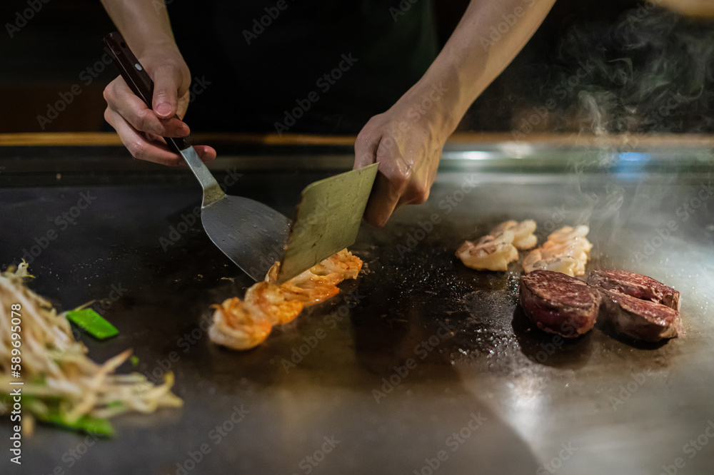 Tepanyaki - japanese grilled beef on pan. chef cooking at the hot table Tepanyaki - japanese grilled beef on pan. chef cooking at the hot table