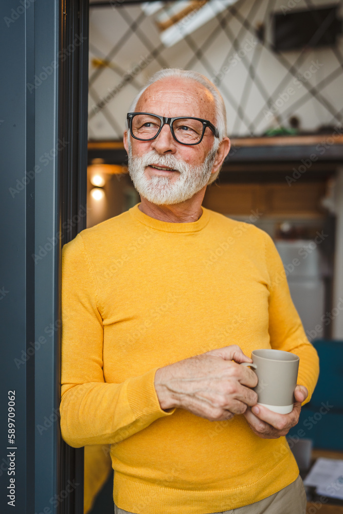 One senior man stand in at door of tiny house happy smile hold cup One senior man stand in at door of tiny house happy smile hold cup
