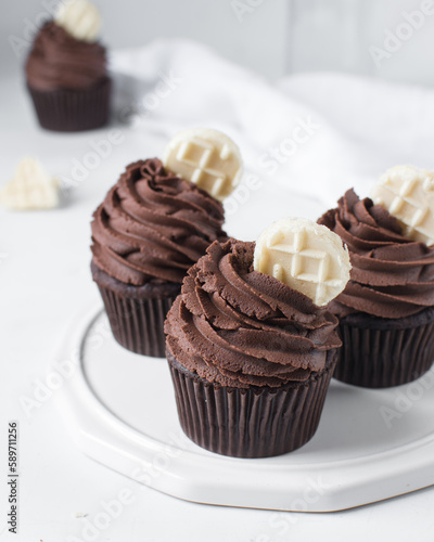 Chocolate cupcake with dark chocolate buttercream, double chocolate cupcakes with american buttercream, tall swirl frosting on a cupcake with a wafer