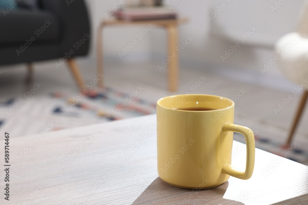 Yellow mug of tea on wooden table indoors, space for text Yellow mug of tea on wooden table indoors, space for text