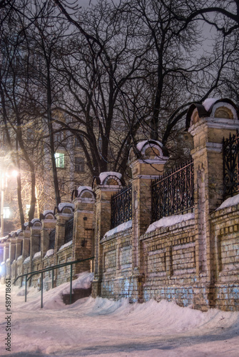 decorative brick and wrought iron wall old town Kyiv in snow at night