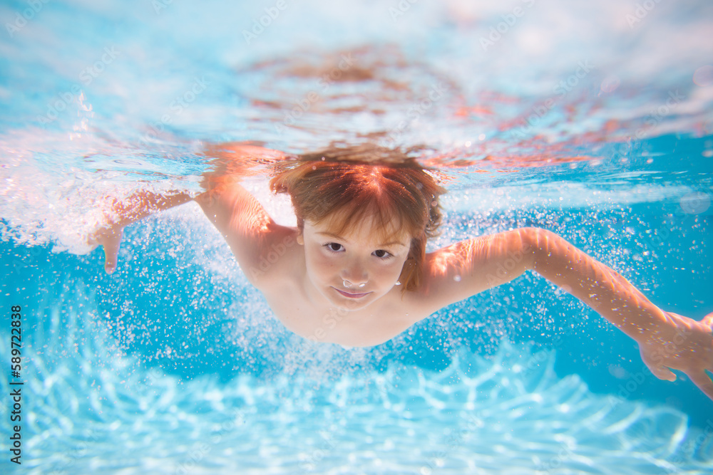 Child in pool in summer day. Kid boy swimming underwater on the beach on sea in summer. Blue ocean water. Child boy swimming in sea.