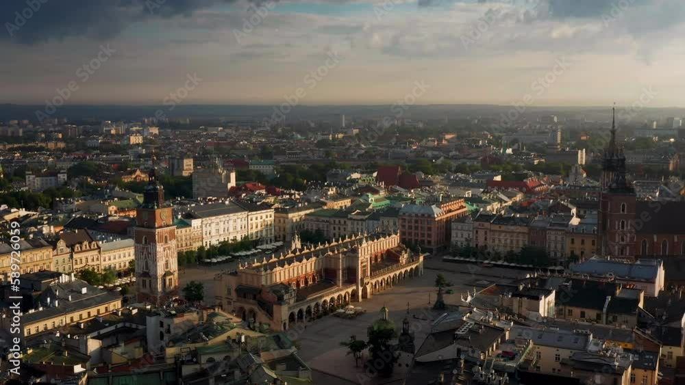 Panorama of Main Square (Saint Mary's Basilica, Sukiennice - Town Hall, Town Hall Tower) in Krakow, Poland during magic stormy weather with soft morning light. Panorama of Main Square (Saint Mary's Basilica, Sukiennice - Town Hall, Town Hall Tower) in Krakow, Poland during magic stormy weather with soft morning light.
