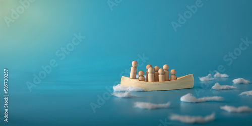 Leadership, teamwork and courage concept. Wooden boat on blue background.