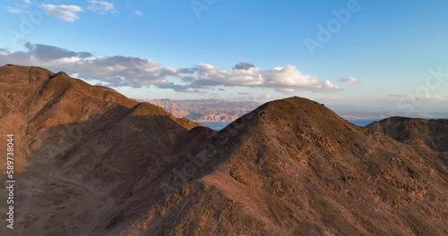 Aerial footage of the mountains of Eilat, In the background eilat city and the Red Sea just before the sunnset. Filmed in C4K Apple ProRes 422 HQ