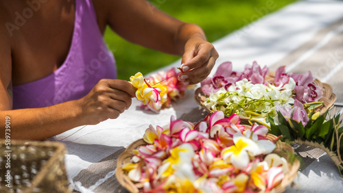 Woman making Hawaiian Lei and Hahu. Process of Handmade flower crown made from Hawaii flower Plumeria. photo