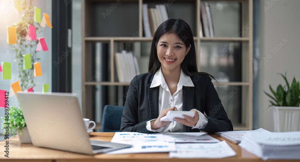 Woman accountant using calculator and computer in office finance and accounting concept Woman accountant using calculator and computer in office finance and accounting concept