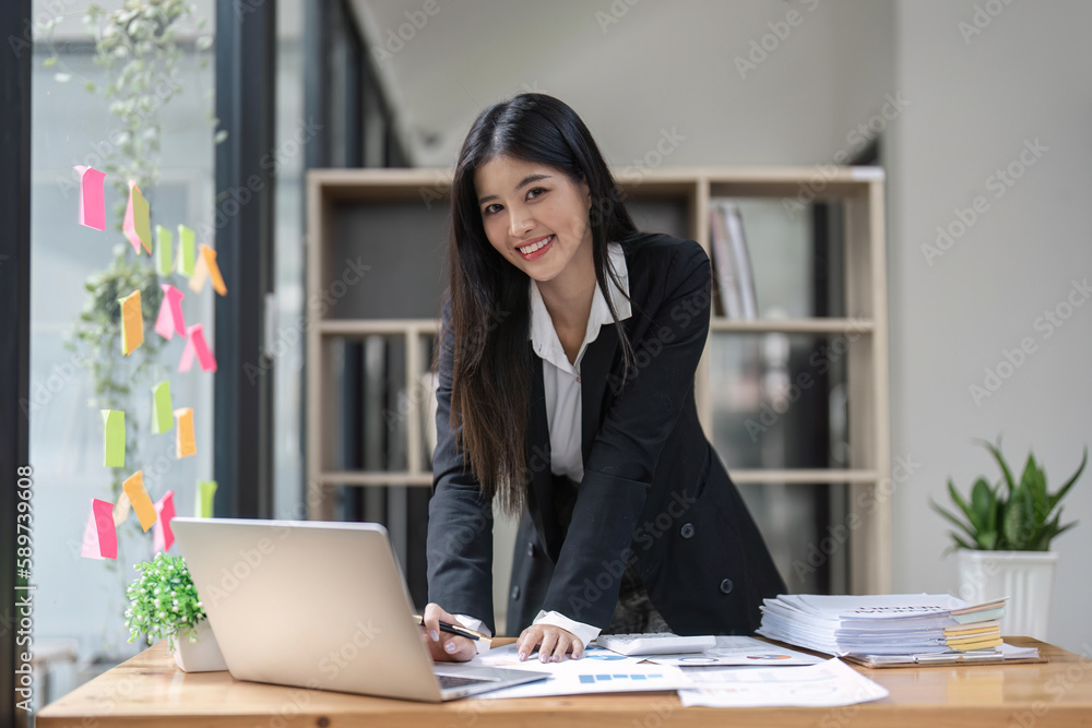 Young happy business woman worker at desk working on laptop in corporate office Young happy business woman worker at desk working on laptop in corporate office