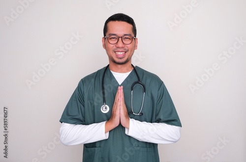 Asian doctor smiling friendly doing greeting pose photo