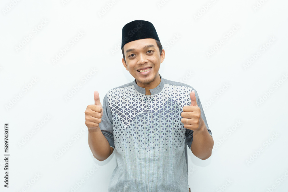 Portrait of Indonesian Asian Muslim man showing thumbs up as an appreciation gesture Portrait of Indonesian Asian Muslim man showing thumbs up as an appreciation gesture