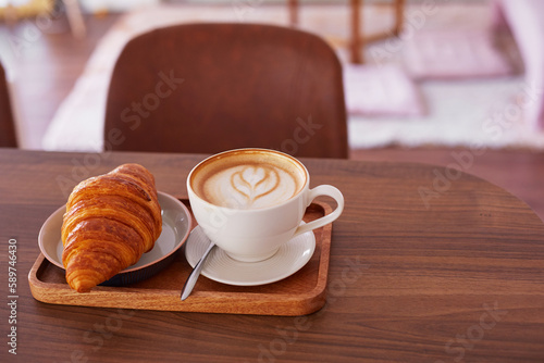   up of coffee and a croissant in a cafe.