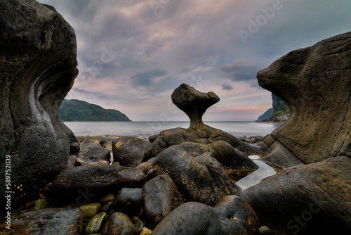 norway, Unusual stone in Atlantic ocean coast. View on Kannesteinen and Kvalheimsvika. Over thousands of years, ocean waves have ground the rock to the special shape it has today.	