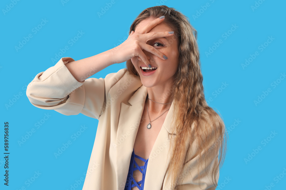 Fototapeta premium Beautiful young woman in jacket on blue background