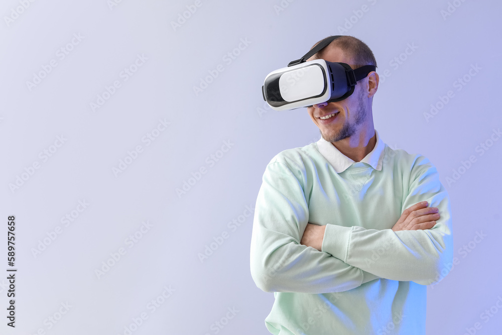 Young man using VR glasses on light background Young man using VR glasses on light background