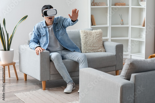 Young man using VR glasses ...