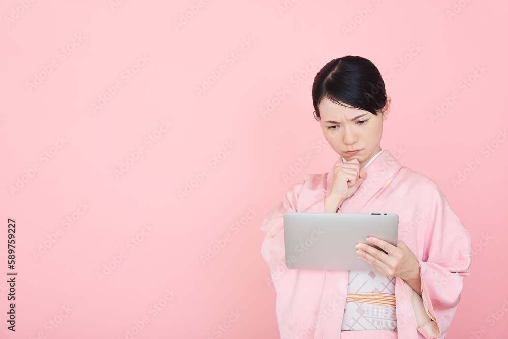 タブレットを操作する着物を着た女性