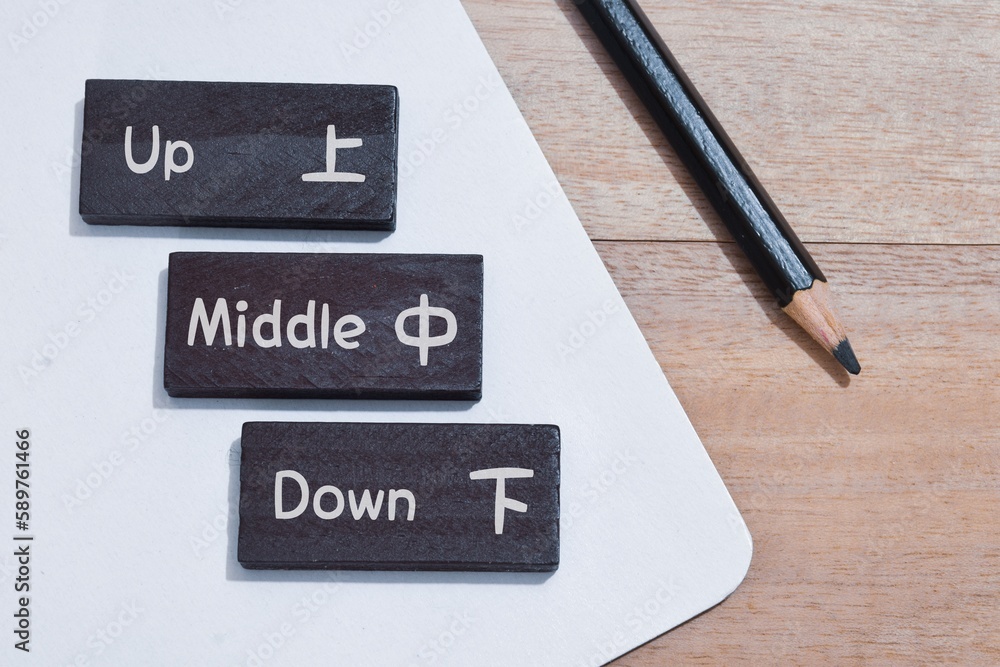 Up middle down with their respective Chinese characters on wooden chips. Chinese language learning concept. Up middle down with their respective Chinese characters on wooden chips. Chinese language learning concept.