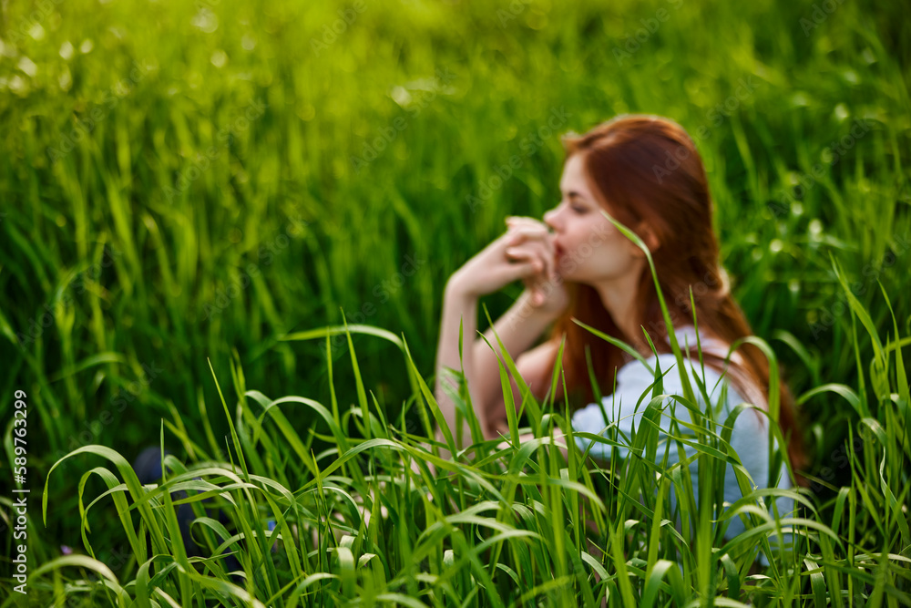photograph of a woman sitting in the grass out of focus photograph of a woman sitting in the grass out of focus