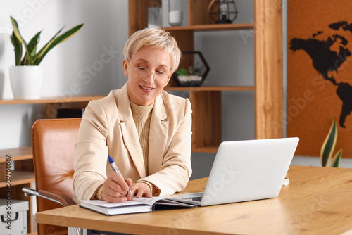 Mature businesswoman writin...
