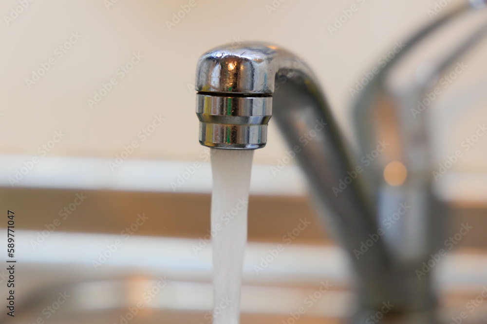 洗面台の蛇口から水が出ている 洗面台の蛇口から水が出ている