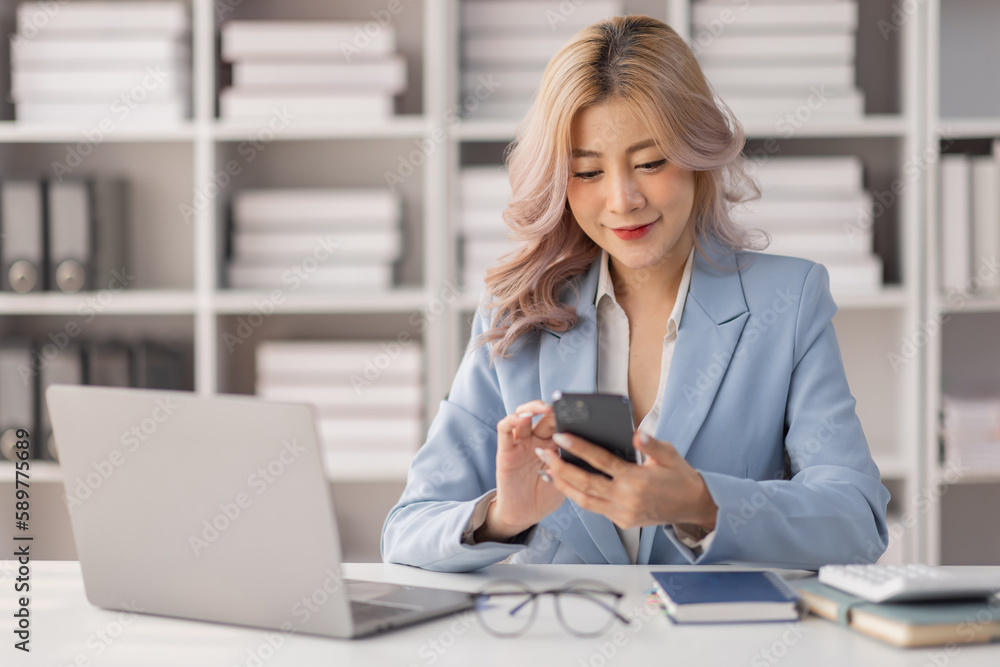 Asian women hold smartphone and use pc at the workplace. Project stats financial data sales charts on laptop and cellphone
Asian women hold smartphone and use pc at the workplace. Project stats financial data sales charts on laptop and cellphone