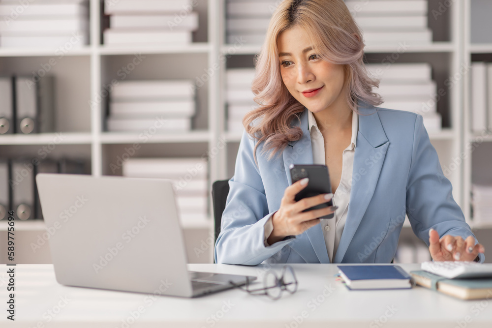 Asian women hold smartphone and use pc at the workplace. Project stats financial data sales charts on laptop and cellphone
Asian women hold smartphone and use pc at the workplace. Project stats financial data sales charts on laptop and cellphone