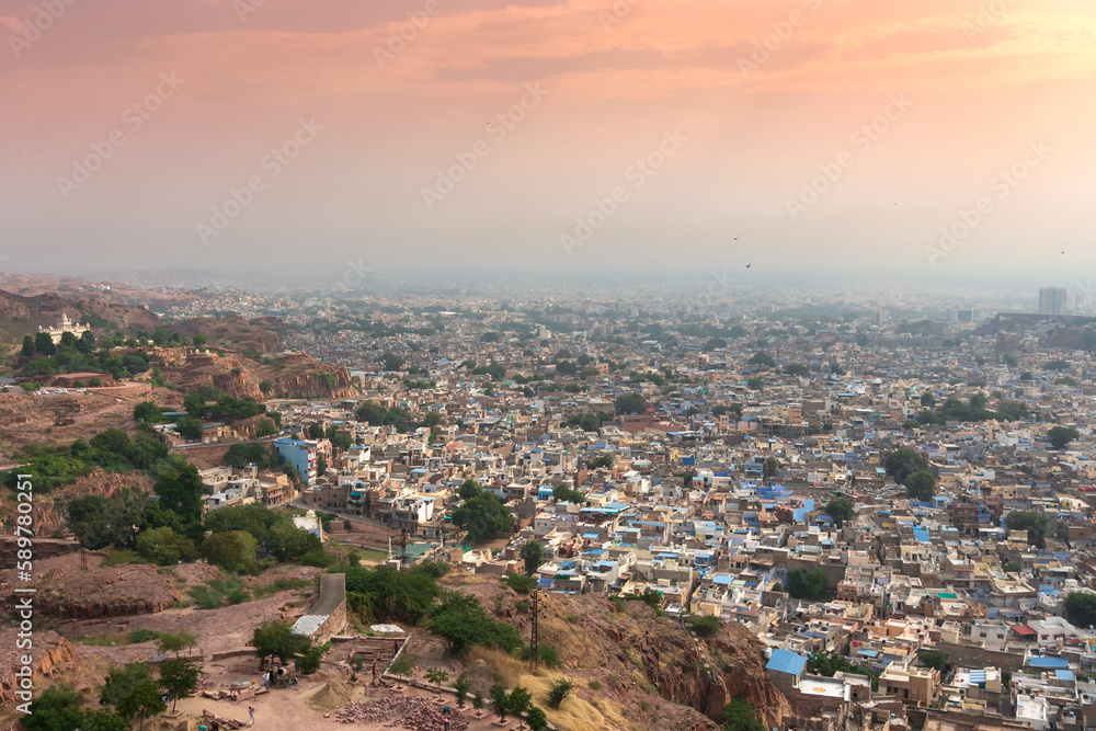 Top view of Jodhpur city as seen from famous Mehrangarh fort, Jodhpur, Rajasthan, India. Orange sky in the background. Mehrangarh Fort is UNESCO world heritage site popular amongst tourists worldwide.