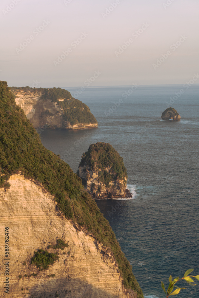 Piękne klify na tle zachodzącego słońca i oceanu, Nusa Penida, Indonezja.