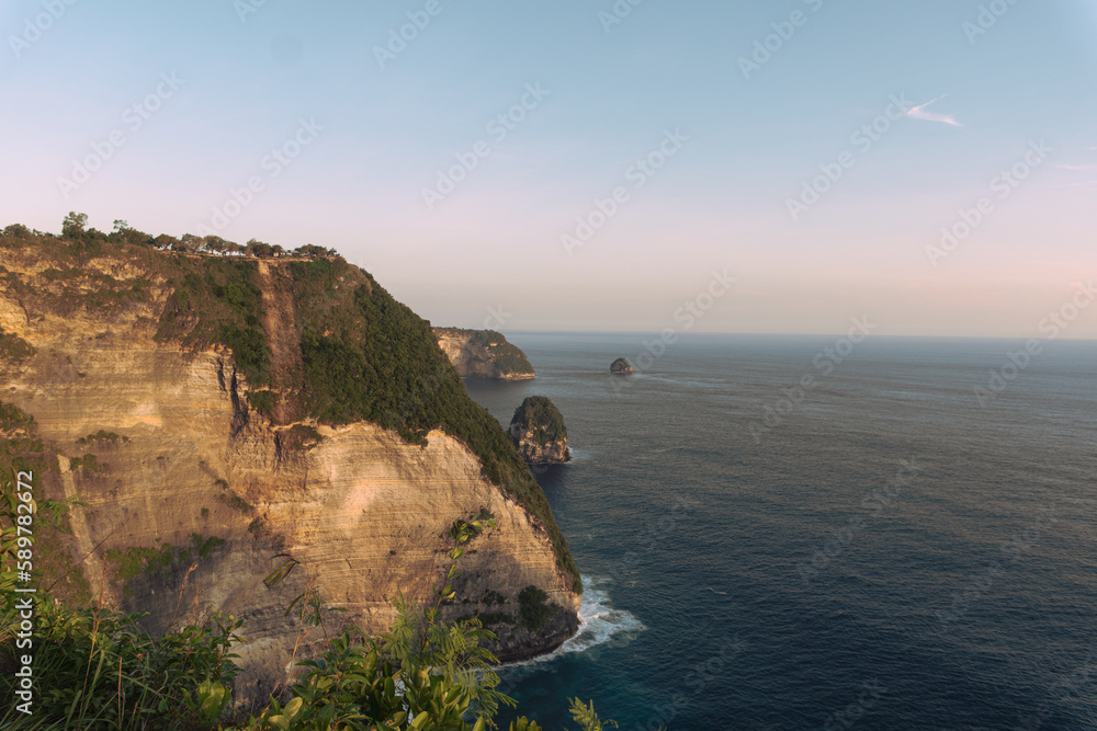 Piękne klify na tle zachodzącego słońca i oceanu, Nusa Penida, Indonezja.