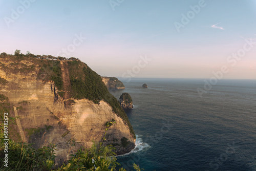 Obraz na płótnie Piękne klify na tle zachodzącego słońca i oceanu, Nusa Penida, Indonezja. w salonie