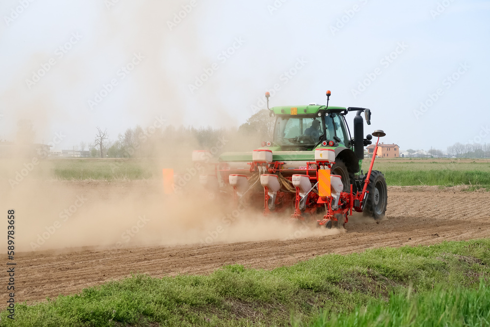 Fototapeta premium Tractor sowing corn dust earth climate change panorama landscape characteristic nature cultivation Italy Italian