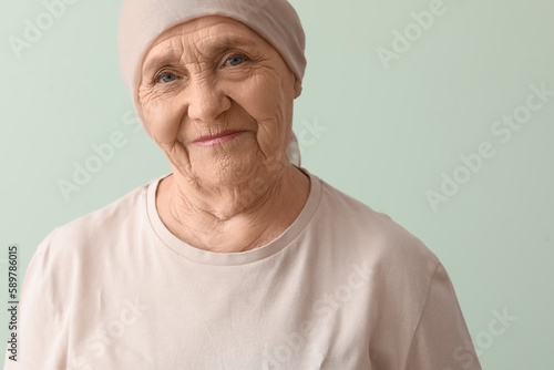 Fototapeta Senior woman after chemotherapy on green background, closeup