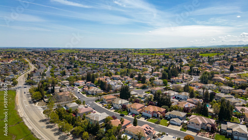 Drone photos over the city of Antioch, California on a beautiful sunny day with green hills, streets, houses, cars and solar.