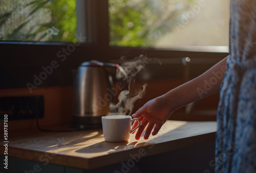 Woman is drinking coffee   morning routine. Tiny house. First property. Small apartment interior design. Minimalism. Moving in. Living alone. Charming trailer house with the morning sun