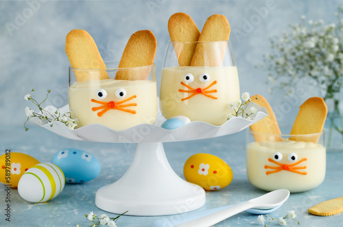 Easter dessert vanilla pudding rabbit  with ears cookies in a glass cup. Spring Easter symbol. Fun kids food. Selective focus.