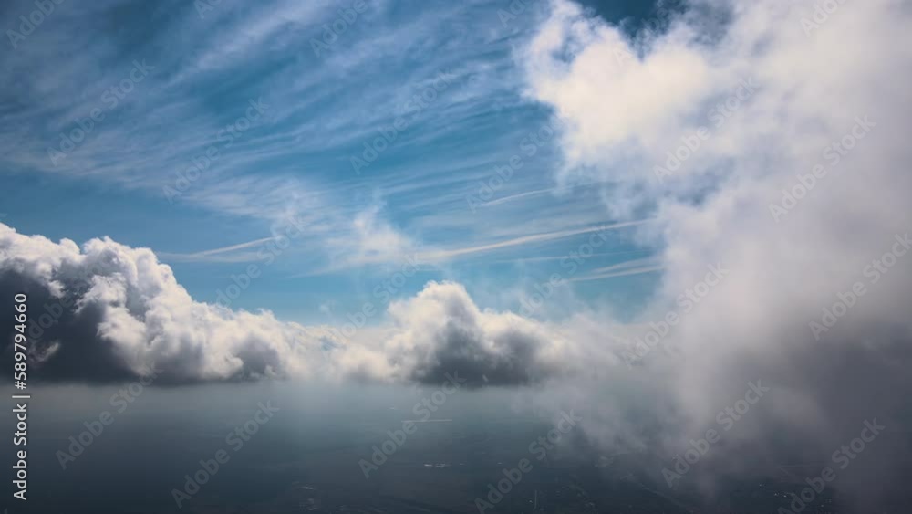 Aerial view from airplane window at high altitude of earth covered with white puffy cumulus clouds Aerial view from airplane window at high altitude of earth covered with white puffy cumulus clouds